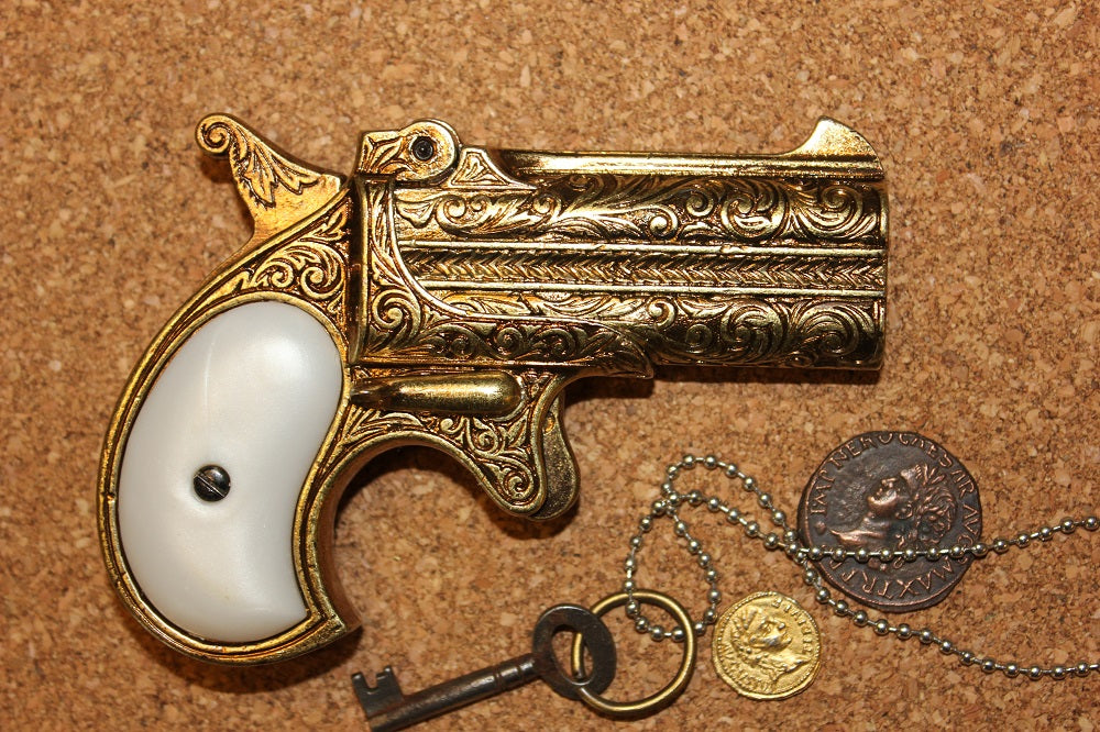 Double-Barrel Derringer 1866 Replica Pistol (Engraved Brass), right side with a key, chain and coins