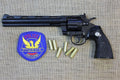 Colt Python .357 8in Replica Revolver, left side with a police patch and dummy rounds