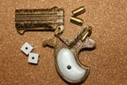 Double-Barrel Derringer 1866 Replica Pistol (Engraved Brass), barrels tipped open, with dice